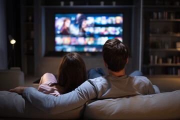 Couple watching a streaming movie on a couch at home, streaming provider, streaming services 