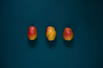 Organic ripe yellow-red pears on a dark background.