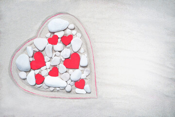 Heart made of white stones on a sand background. Wooden red hearts between stones. Valentine's day, mother's, woman's day, honeymoon, vacation, summer. Empty place (pattern). Flat lay.
