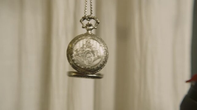 Antique silver pocket watch with its metallic chain.