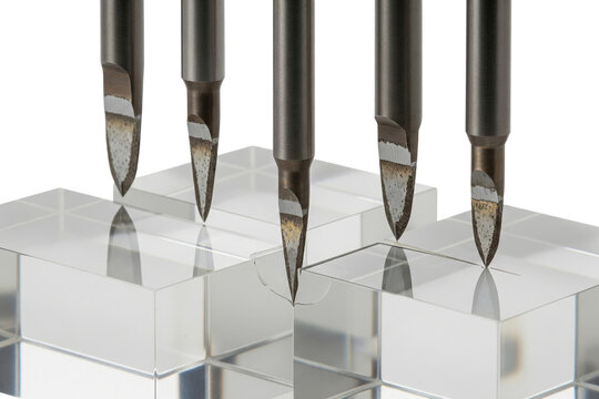 Sharp metal industrial cutting tools scribing clear glass blocks on a transparent background