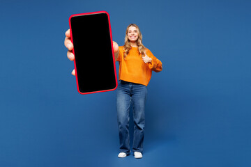 Full body young happy woman wear yellow sweater casual clothes hold in hand use mobile cell phone...