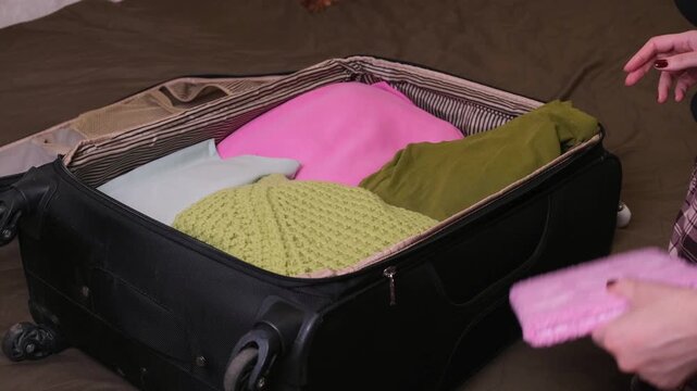 A woman packs a suitcase for a trip, puts things and a vibrator in it. An intimate accessory as an everyday attribute of a vacation.