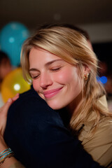 Woman embracing friend at a cheerful party event