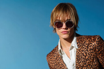 Young man wearing sunglasses and leopard print jacket