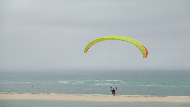 Parapentiste solitaire survolant les eaux du Bassin d'Arcachon face au Banc d'Arguin depuis la Dune du Pilat.