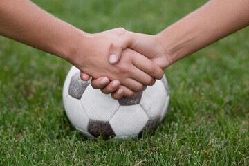 Players shake hands before soccer match on the field