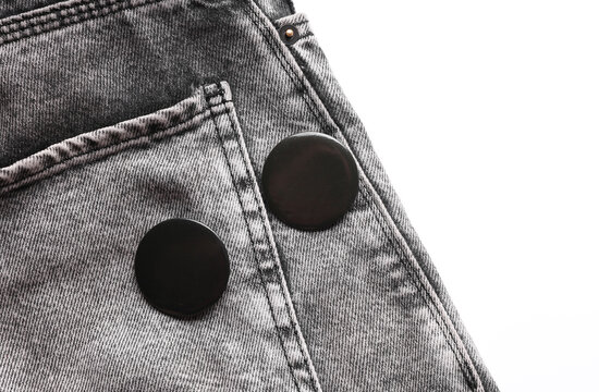 Black pin button tags on jeans close up