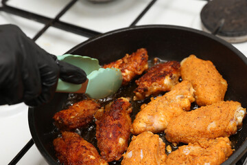 Chicken wings are fried in a frying pan