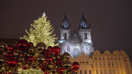 Prague, Czech Republic – December 21, 2025: Large christmas tree and festive holiday decorations on the old town square with Tyn church visible in the background at night.
