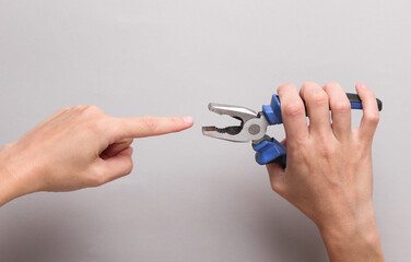 The finger of the hand is put under the nippers. Danger of handling the tool, safety precautions