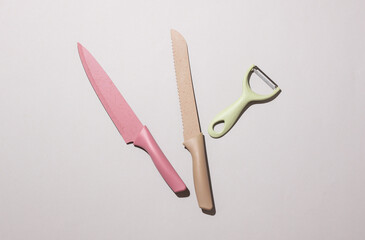 Set of colored kitchen ceramic knives on gray background. Top view. Flat lay