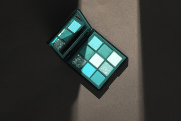 Eye shadow palette on gray background with stripe of light and shadow. Minimalism. Beauty Concept photo