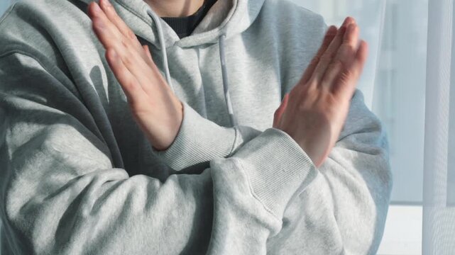 Arm-crossing gesture.
Refusal and rejection.
A person makes a gesture of refusal and rejection with their hands.