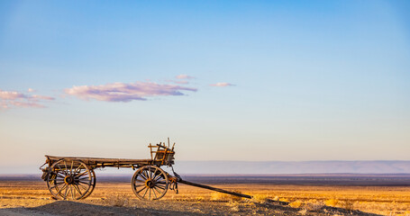 Fototapeta premium Vintage ox wagon abandoned in arid desert