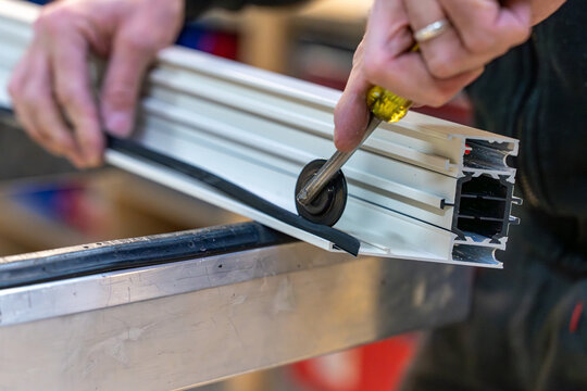 Main d&rsquo;artisan appliquant des joints sur des tubes en PVC, illustrant le travail pr&eacute;cis et professionnel de la plomberie ou de la construction.