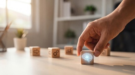 Adult mans hand placing a wooden cube with a glowing brain icon, symbolizing innovation and intelligence, on a desk with other business concept blocks