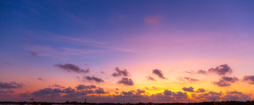 Vibrant Panoramic Sunset Sky with Dramatic Pink and Orange Clouds,A breathtaking panoramic view of a sunset sky featuring a vivid transition from deep blue to brilliant orange and pink hues,