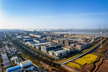 Large modern industrial park with wind turbines along the coast under bright sunlight. © zhao dongfang