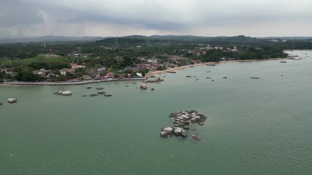 Sea with a rocky shoreline. The shoreline is lined with houses and buildings. Aerial view Tanjong Bidara, Melaka
