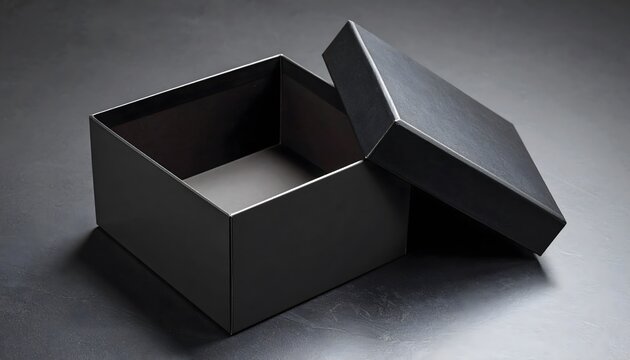 Open black box with lid resting on dark textured surface, minimalist presentation