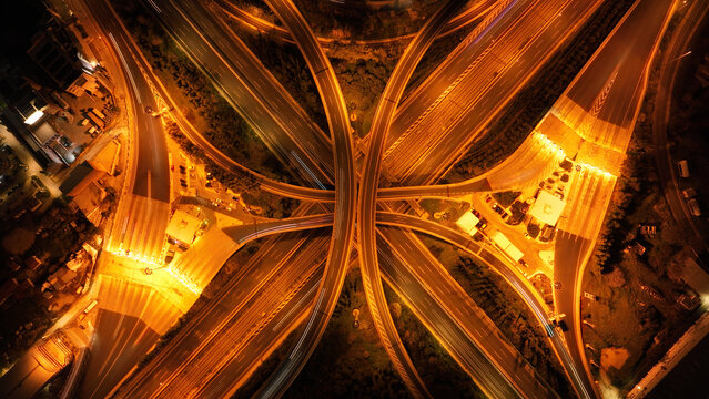 Aerial drone slow shutter night shot of illuminated highway multilevel junction in shape of butterfly, a modern, scalable, and practical approach to managing Intelligent Transportation systems