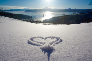 Heart in the snow with a beautiful view
