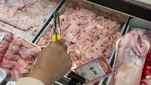hands selecting chicken meat in the supermarket