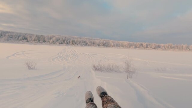 A man is rolling down a hill at high speed on a cheesecake.  Snow tubing. Winter fun. Active winter holidays. From the first person.
