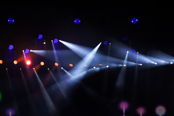 Colorful stage lights illuminate an electrifying concert atmosphere at night