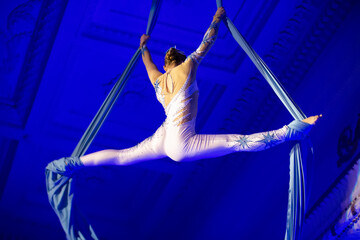 Stunning aerial silk performer captivates audience with graceful moves during evening show in...