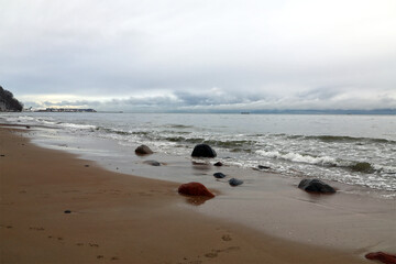 Overcast Day at a Beach with Gentle Waves and Distant Shore © JAROSLAW PIWOWARSKI