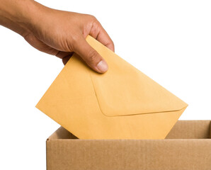A hand is placing a yellow envelope into a cardboard box, suggesting the act of mailing or submitting documents.