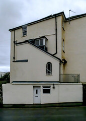 A building with a white facade and a dark roof.