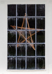 A star made of twigs is placed in a window.