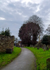 A path through a cemetery on a cloudy day.