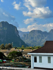 Paramotors flying over Nam Song River and limestone mountains in Vang Vieng, Laos. Stunning landscape of adventure travel destination in Asia.