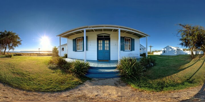 A charming, white house with a blue door and shutters, facing a sunny, grassy yard