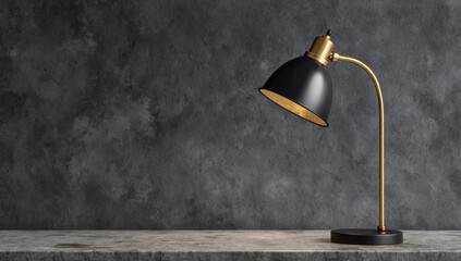 Black and gold desk lamp sitting on a concrete surface against a dark, textured wall