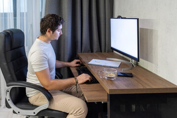 Focused worker at home workstation with computer and coffee cup