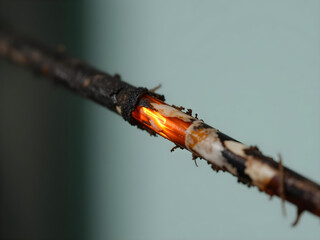A wire is burning and has a hole in it