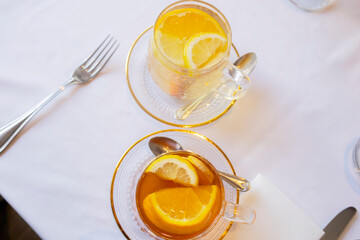 glass cup of tea with lemon on table