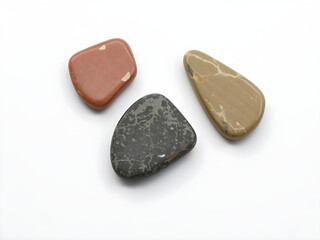 Three rocks of different colors are on a white background