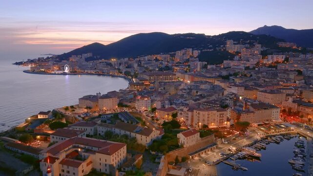 sunset over france coastal town with boats, scenic view of ancient castle and busy marina at dusk. Ajaccio