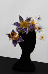 A Floral Fascinator Headgear Hat on a Mannequin Head.