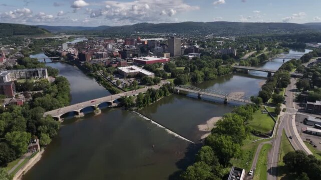 Binghamton, NY downtown city skyline with office buildings, historic architecture, public parks and river flowing through town on Summer sunny warm day