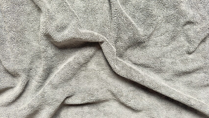 soft gray terry cloth texture with elegant folds creating serene neutral backdrop for wallpaper or...