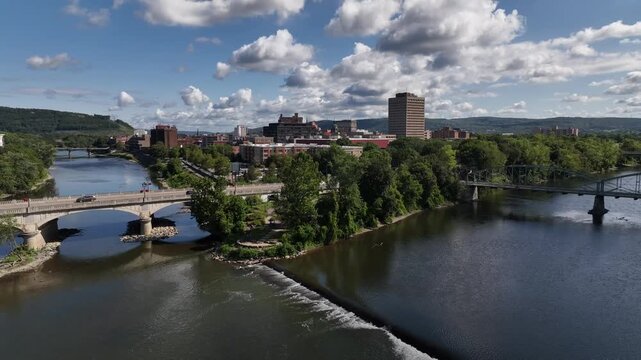Binghamton, NY downtown city skyline with office buildings, historic architecture, public parks and river flowing through town on Summer sunny warm day