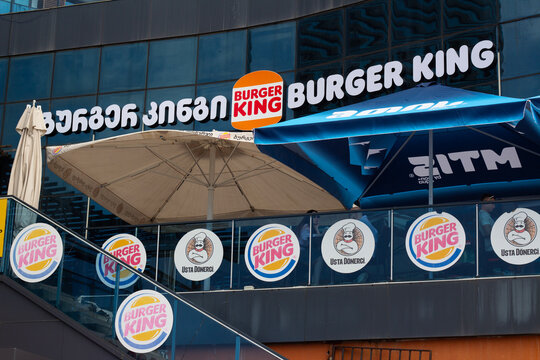 Batumi, Georgia - June 27, 2025: Horizontal street photo. Logo of fast food cafe chain Burger King, Usta Donerci on glass house. Concept of diet, menu, dinner, eat, lunch, fastfood, pick up order
