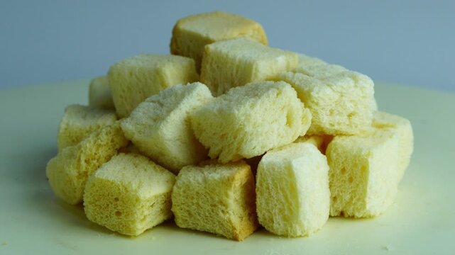 Pile of cube shape crispy dried crouton bread rotate on white background.